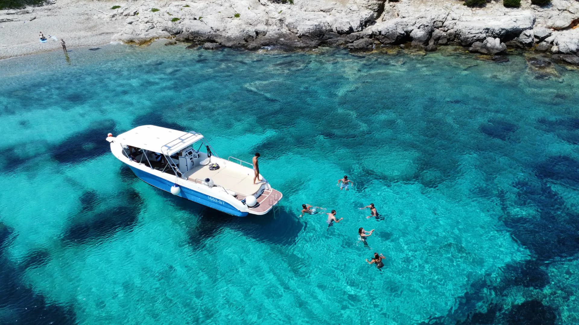 The Drvenik Blue Lagoon from the air, turquoise water over white sand. Blue Cave Group Tour